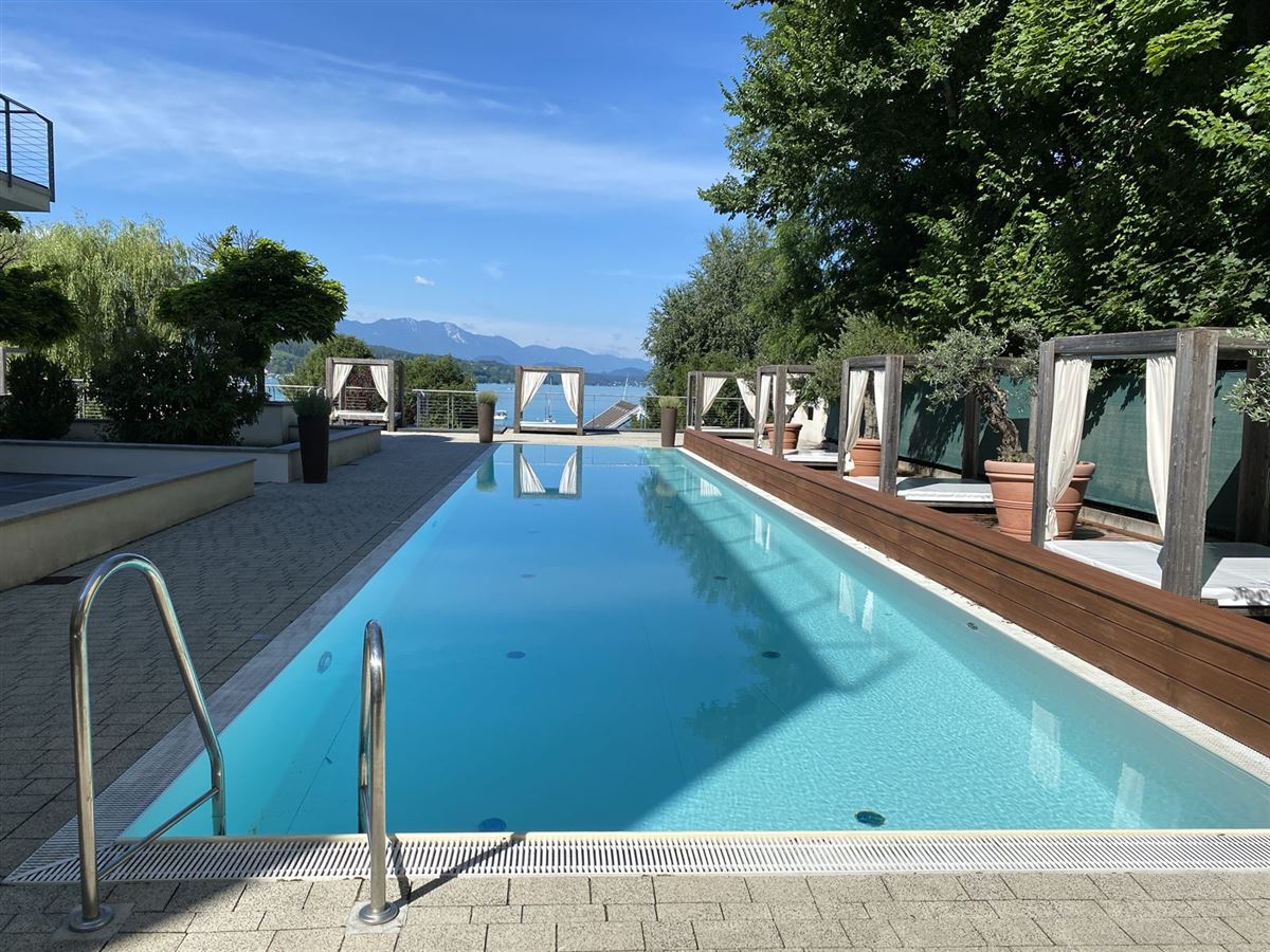 Außenpool mit Cabanas und Blick auf den Wörthersee